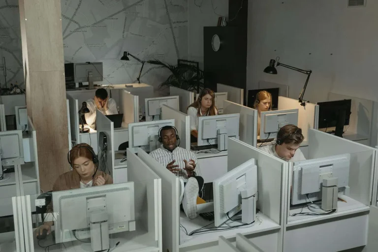Call center agents working at computers in a modern contact center environment representing call monitoring software