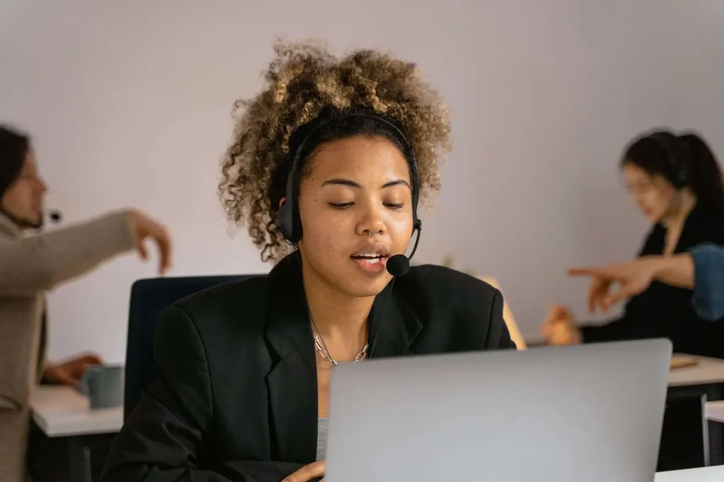 Customer support agent wearing a headset and working on a laptop