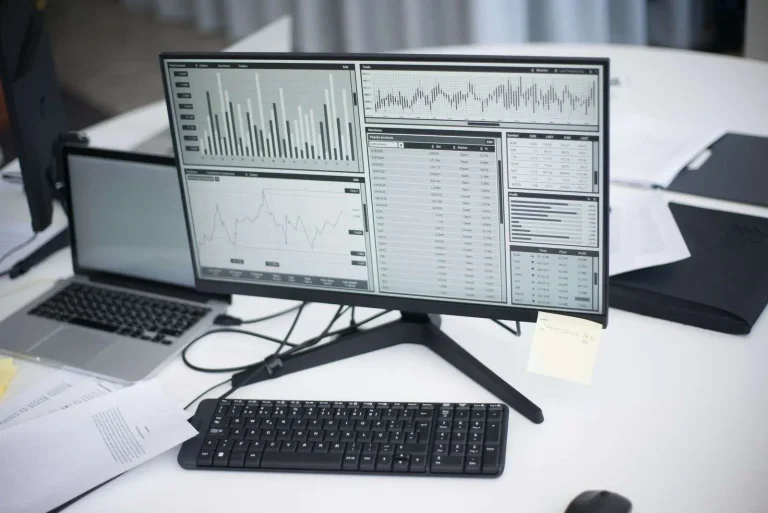 Business professional reviewing AI-powered analytics and data dashboards on a computer in a modern office