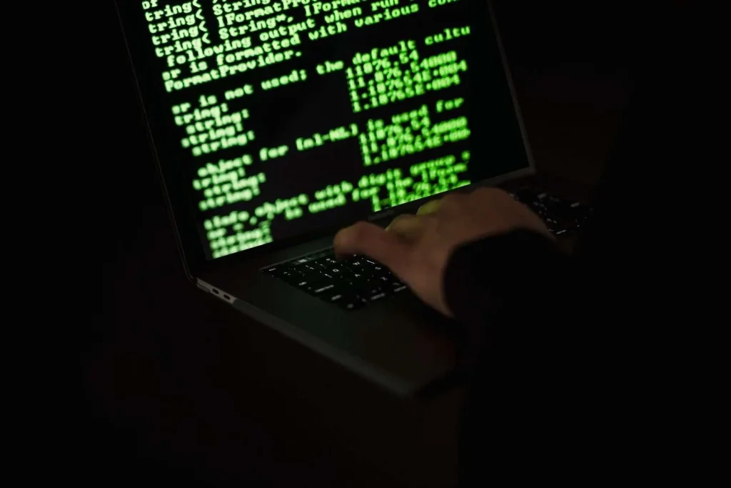 Laptop screen with code representing a ClickFix fake CAPTCHA malware attack using a malicious AI assistant