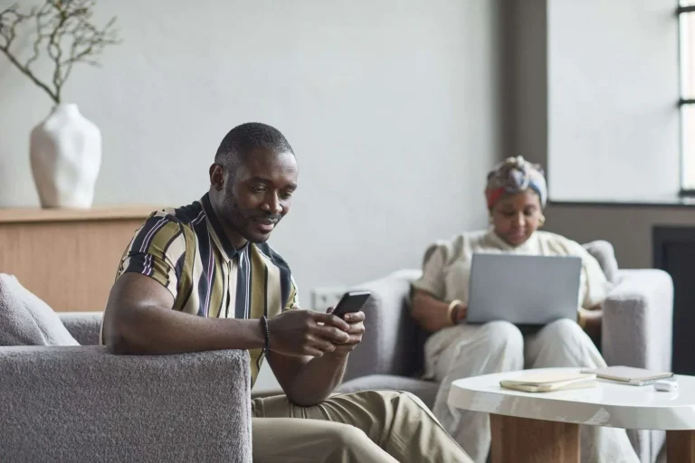 Business travelers using laptops on high-density managed Wi-Fi in a modern hotel lobby
