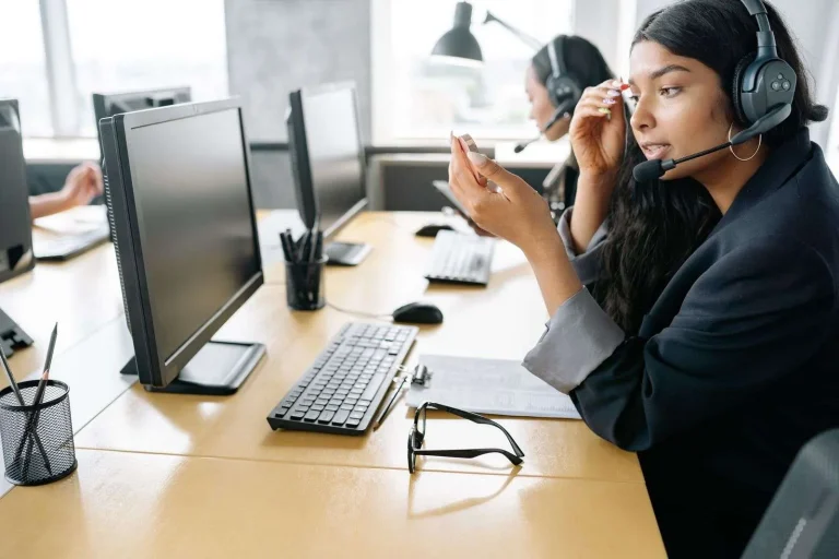 Multichannel Contact Center: What It Is, How It Works, and How to Build One That Lasts 4 Customer support agent wearing a headset working at a computer in a modern office contact center