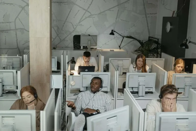 Diverse group of customer service agents with headsets working in a modern contact center