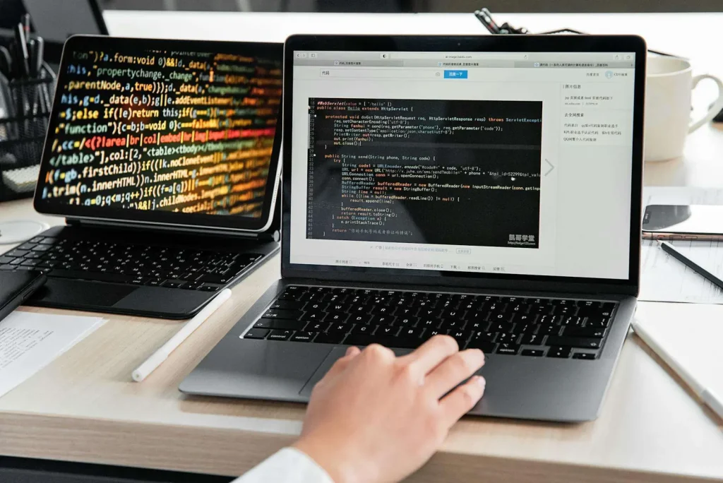 Developer writing code on laptop representing custom software development and business technology solutions