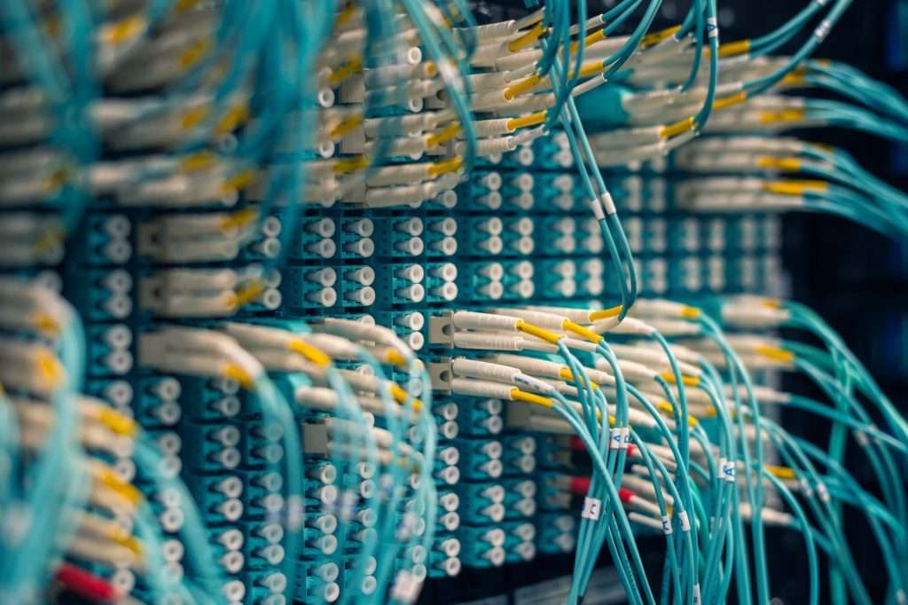 Dense network patch panel with fiber cables representing devices connected to a business network