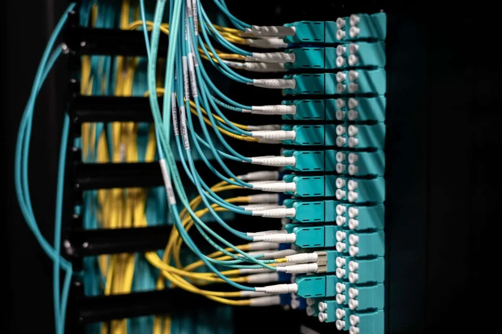 Neatly labeled ethernet patch panel and bundled network cables in an office telecommunications room prepared for a Wi-Fi upgrade