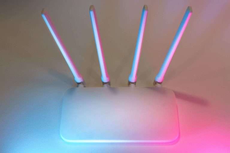 Wi-Fi 8 and AI-Native Gateways Are Coming: Cytranet CTO Doug Roberts on How Businesses and Properties Should Prepare 1 White wireless router with four illuminated antennas glowing in soft blue and pink light